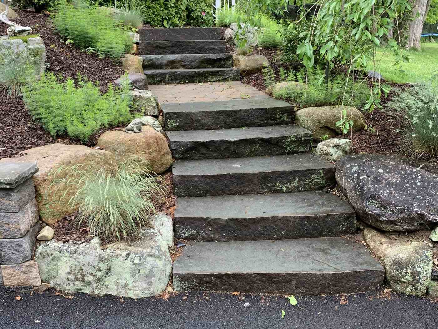 Oversized natural stone steps and boulder terracing for a sloped driveway entry in Ringwood NJ
