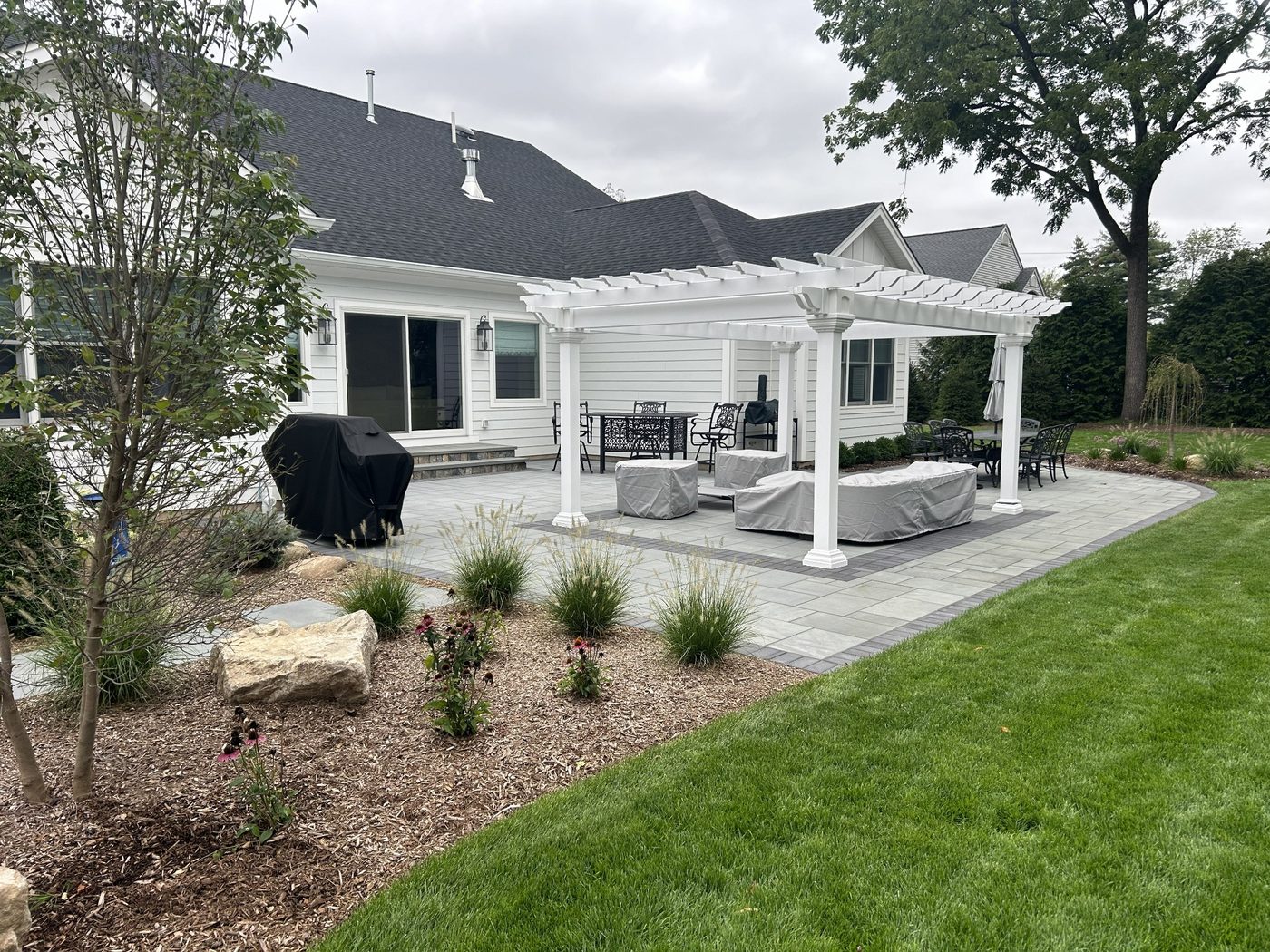 After landscape construction image showing finished backyard landscaping, patio, and pergola installation in Ringwood NJ